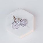 Skylight Hoops in sterling silver on a white stone surface. 