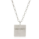 The back of a Virtues Pendant - Square in sterling silver with 'SINCERITY' engraved on a white background. 