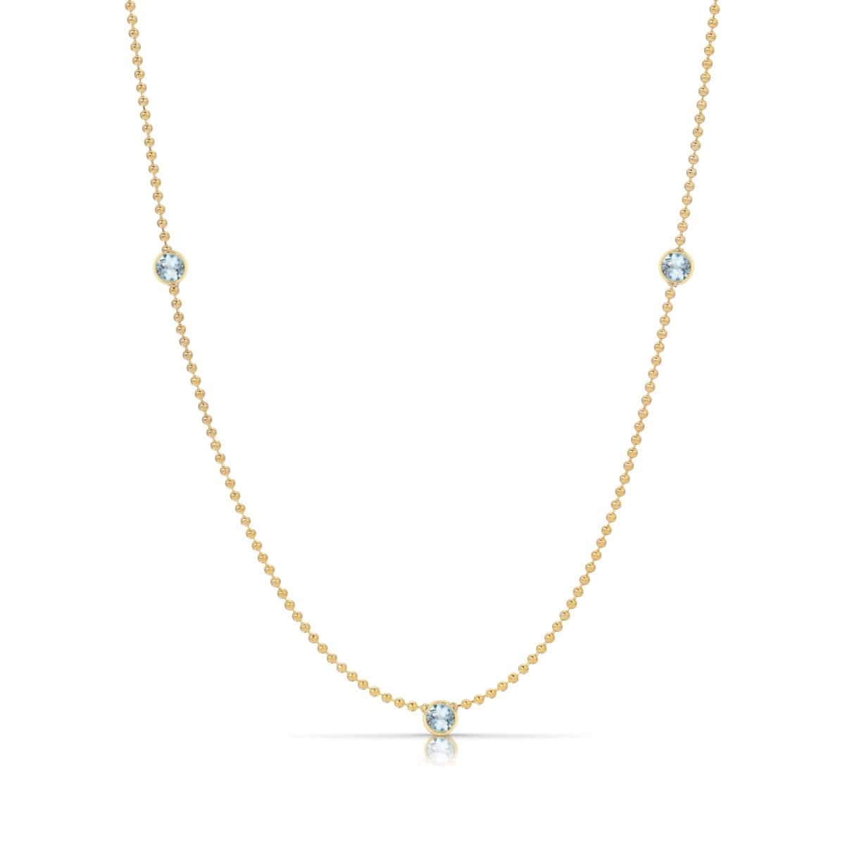A Triple Birthstone Layering Necklace - Yellow Gold in Aquamarine - March on a white background.