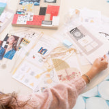 A woman working on jewelry design with Virtues Pendants - Rectangle and Square in yellow gold and sterling silver, a Skylight Necklace in sterling silver laid out with various images. She is wearing Bubble Bracelets and a light pink jumper. 