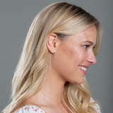 A blonde woman wearing a More Love Stud and Necklace showing her side profile against a grey background. 