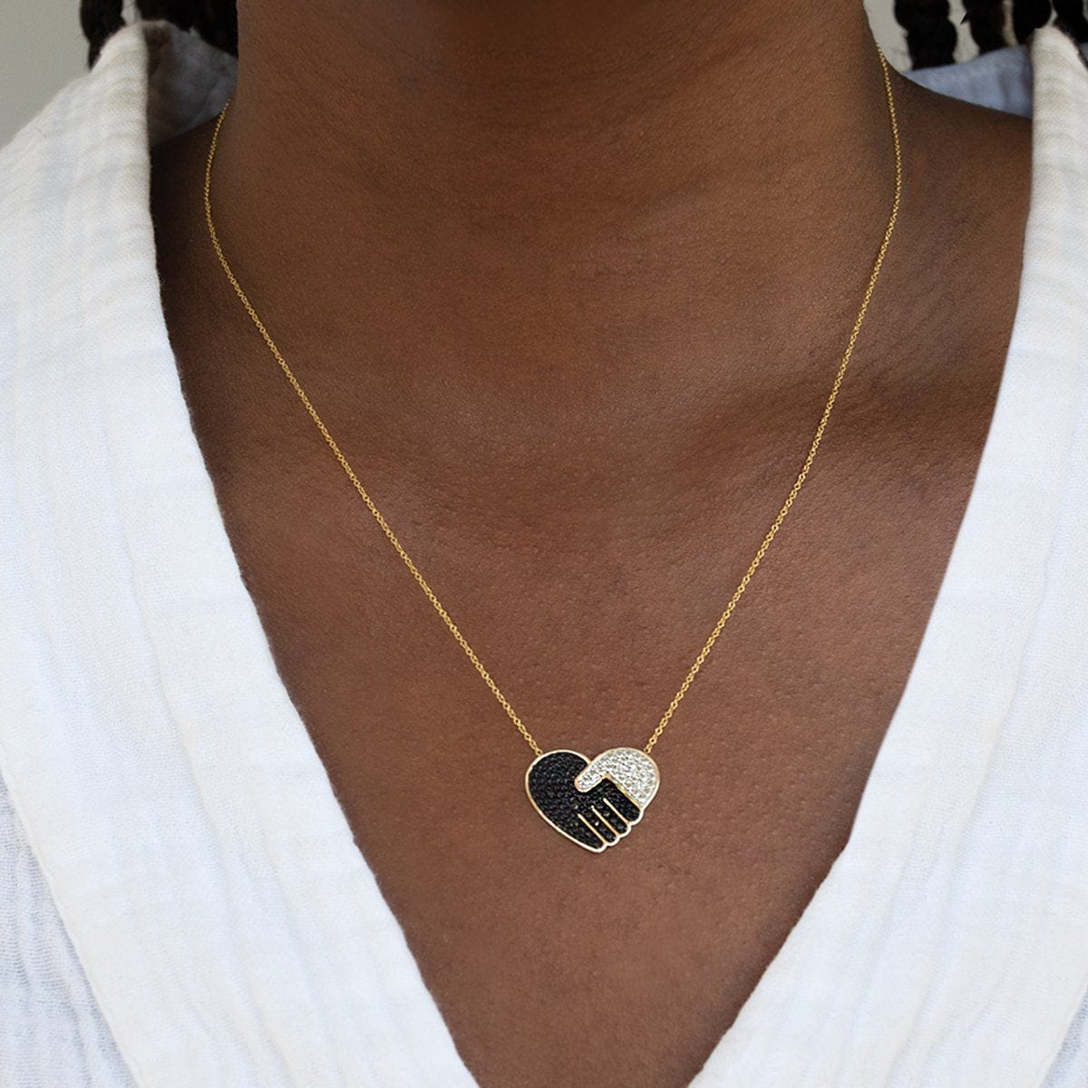 Close-up of a neck wearing a Pavé Unity Pendant - Large with a white top. 